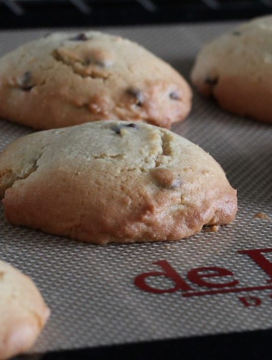Cookies dorés avec chocolate chips fondants sur tapis de cuisson