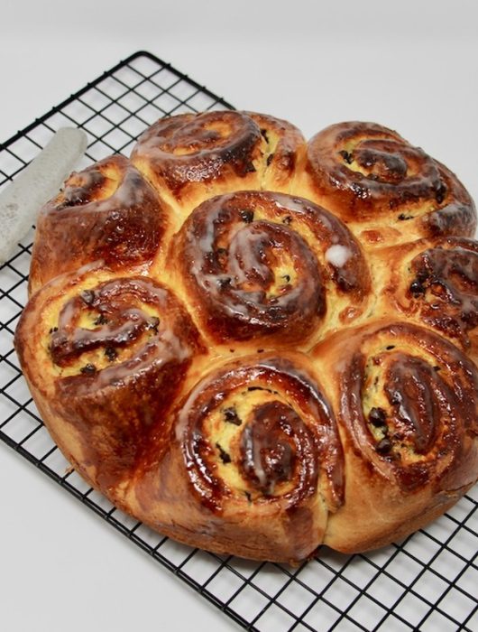 Brioche Chinois dorée et glacée sur grille, accompagnée d'un couteau, illustrant la recette chinois