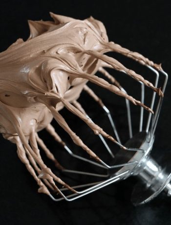 Fouet recouvert de ganache montée chocolat onctueuse et brillante sur fond noir