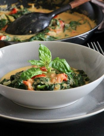 Poêlée épinards tomates servie dans un bol gris, garnie de basilic frais