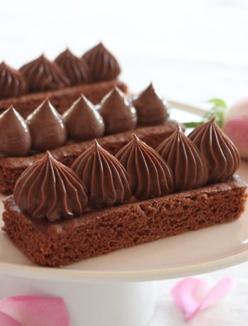 Crèmeux chocolat dressé sur biscuits rectangulaires avec roses roses en arrière-plan
