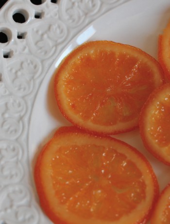 Tranches d'orange confite brillantes sur une assiette blanche décorative