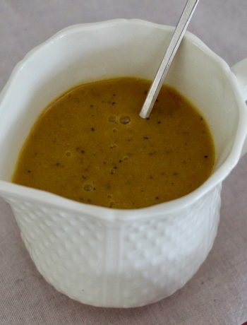 Purée de passion dorée dans une cruche blanche texturée avec cuillère argentée