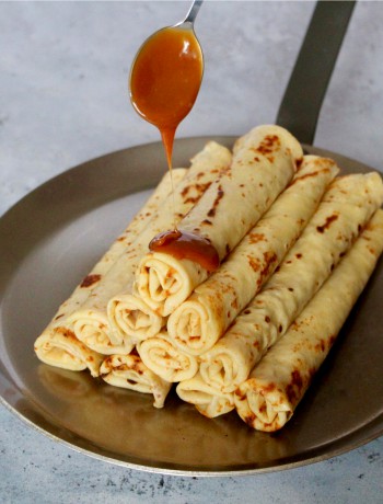 Crêpes roulées sur assiette, nappées de caramel, mettant en valeur la crepe paul bocuse