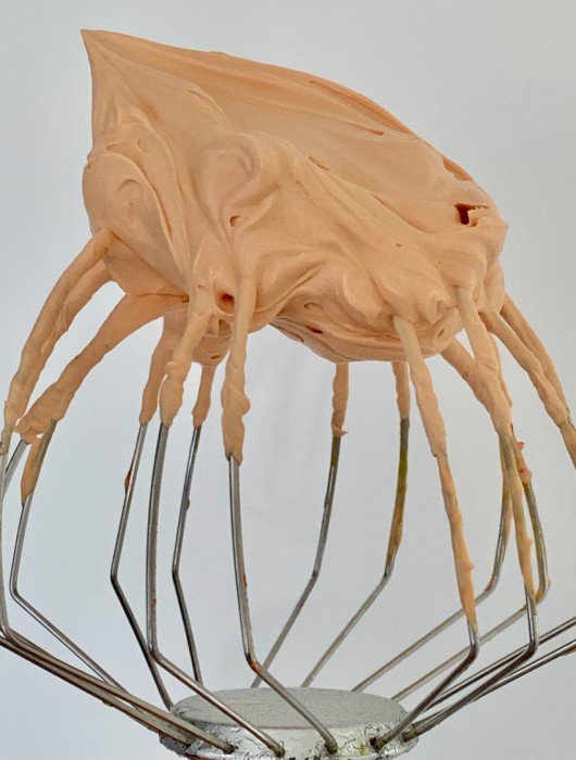 Texture onctueuse de ganache caramel beurre salé sur fouet métallique argenté