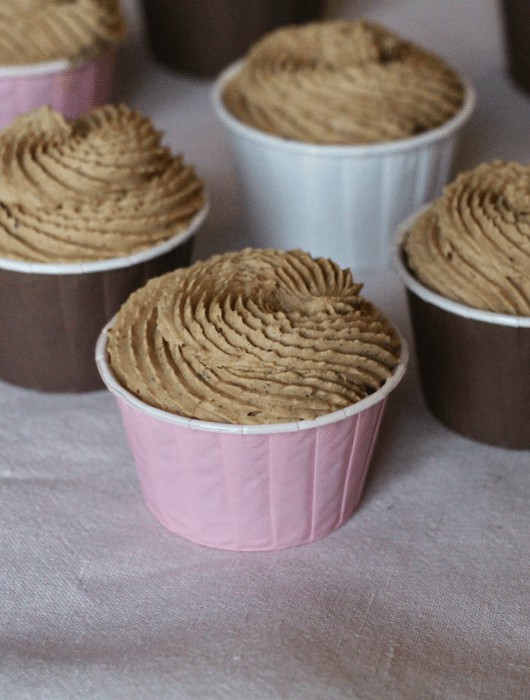 Cupcakes garnis de ganache montée praliné, présentés dans des caissettes colorées