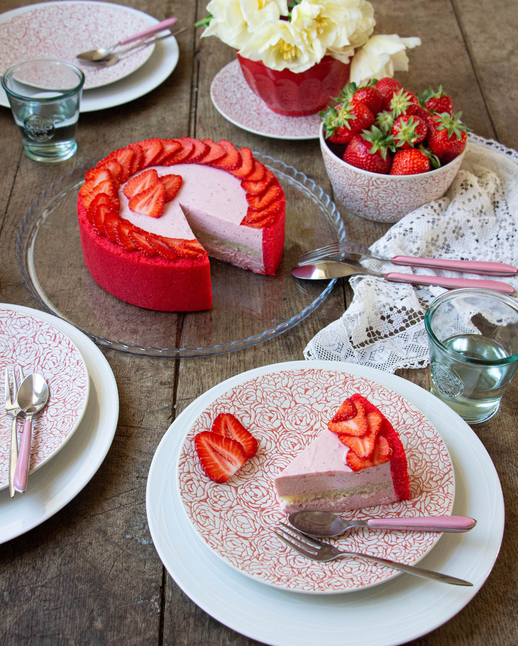 Slice of strawberry Bavarian cream on a floral plate, decorated with fresh strawberries
