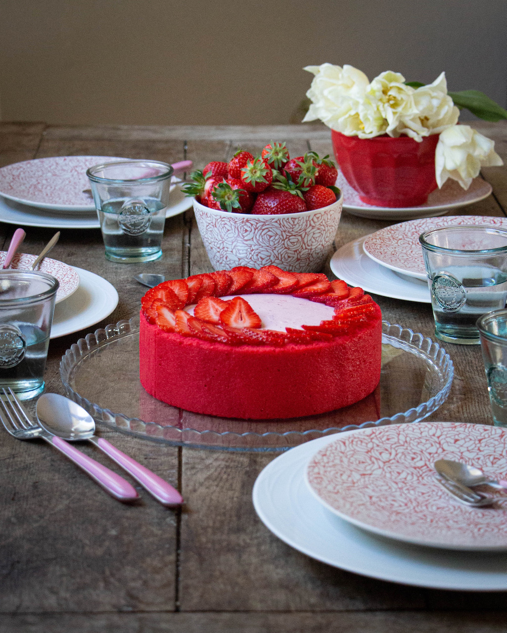 Strawberry Bavarian cream garnished with slices of strawberries on a glass plate, rustic ambiance