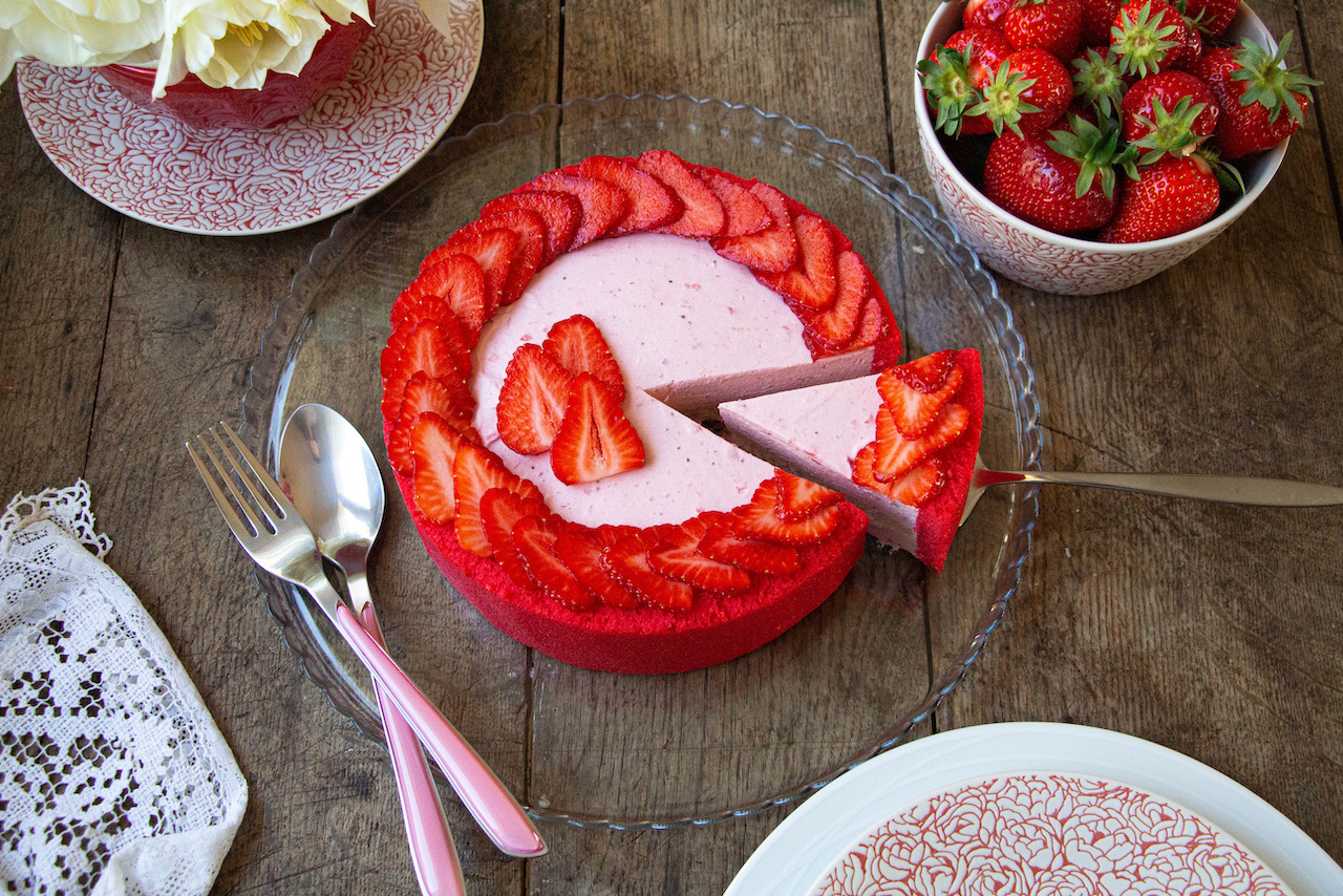 Slice of strawberry Bavarian cream, decorated with fresh strawberries on a glass plate