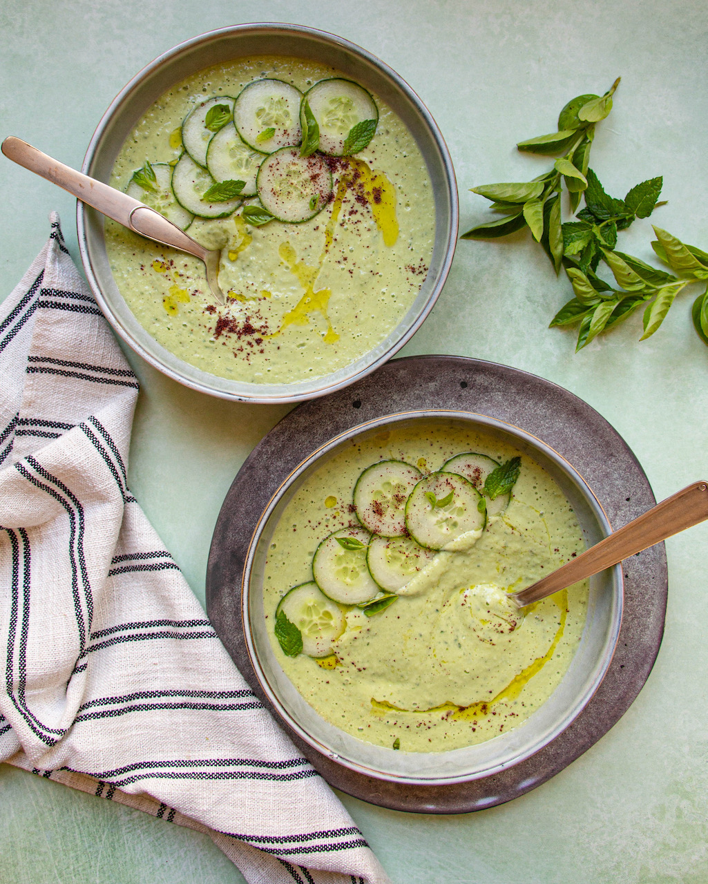 Creamy cucumber gazpacho garnished with cucumber slices and mint leaves