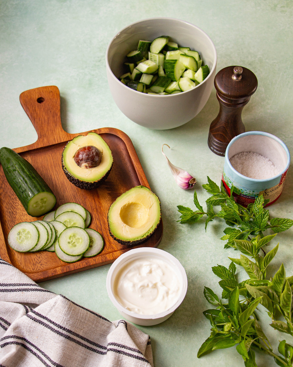 Sliced avocado and cucumbers prepared for a fresh cucumber gazpacho