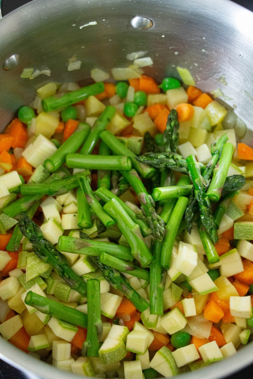 Green asparagus and colorful vegetables simmer for a spring dish with friends