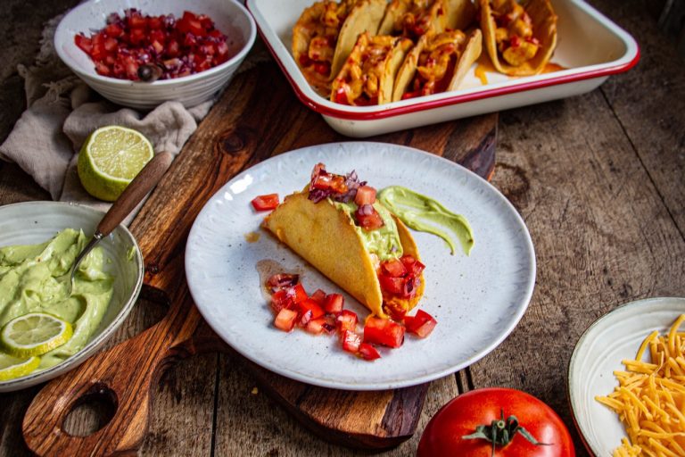 Taco mexicain garni de poulet, avocat crémeux et dés de tomate rouge