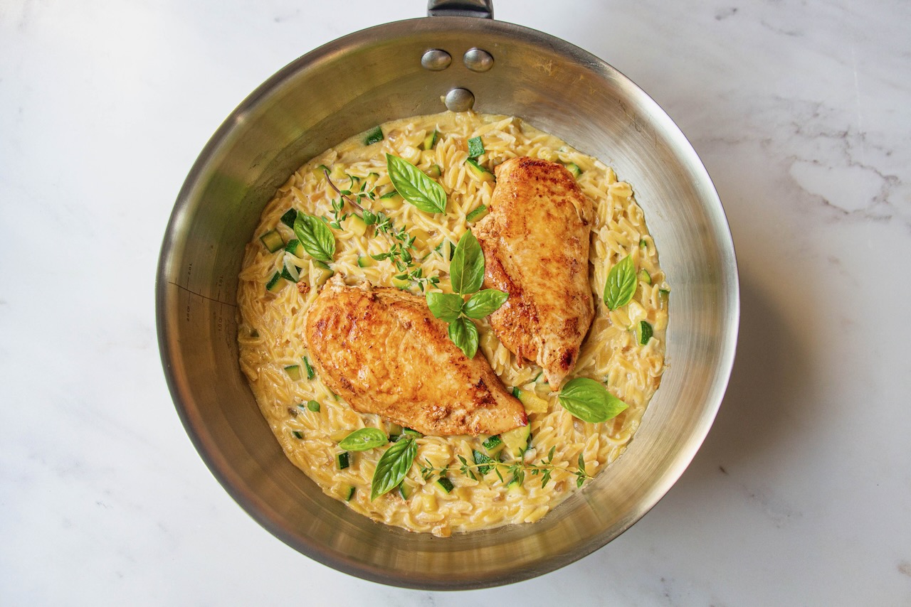 Golden chicken on creamy orzo, zucchini, and basil, a delicious orzo recipe