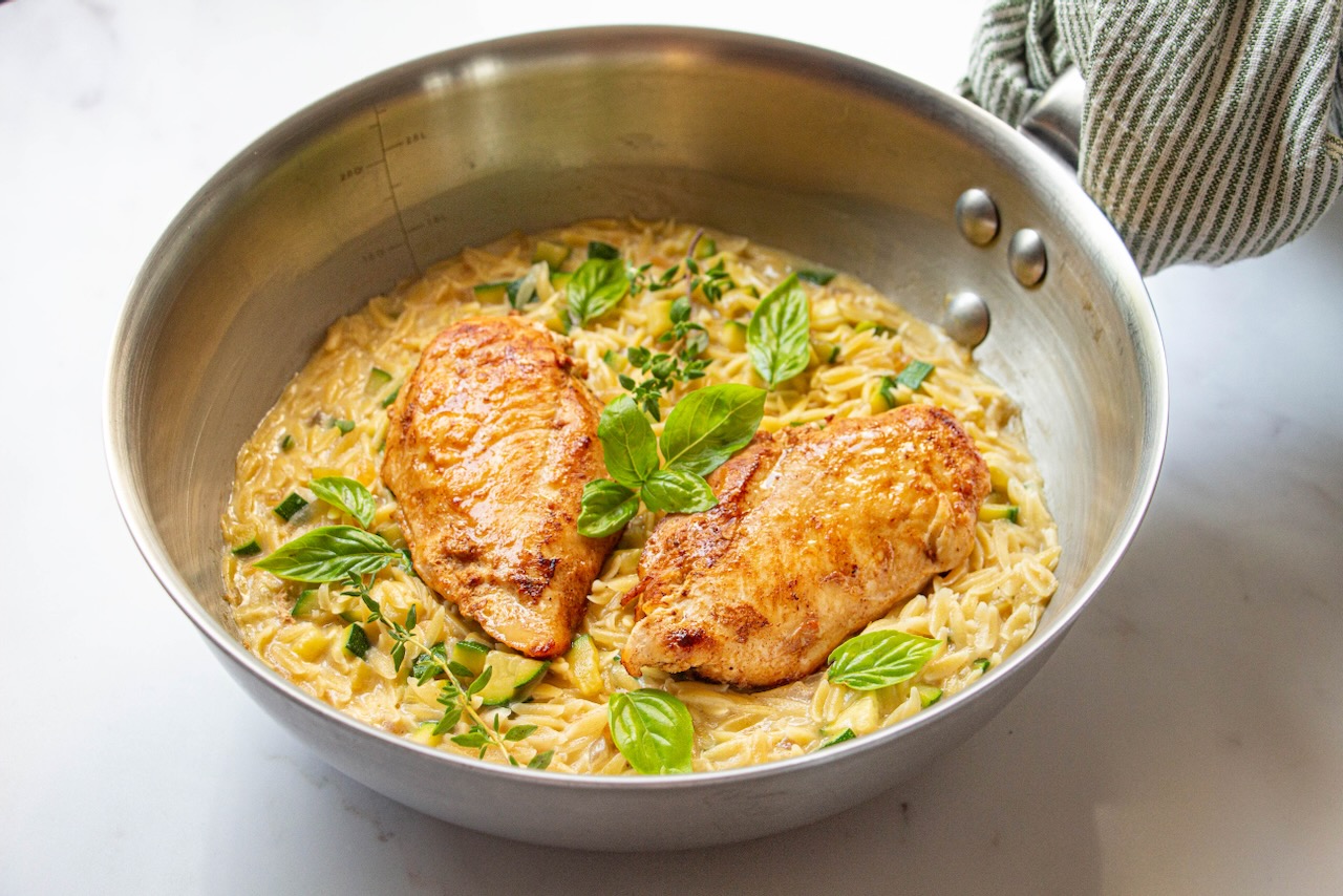 Golden chicken on creamy orzo, basil leaves, a gourmet orzo recipe
