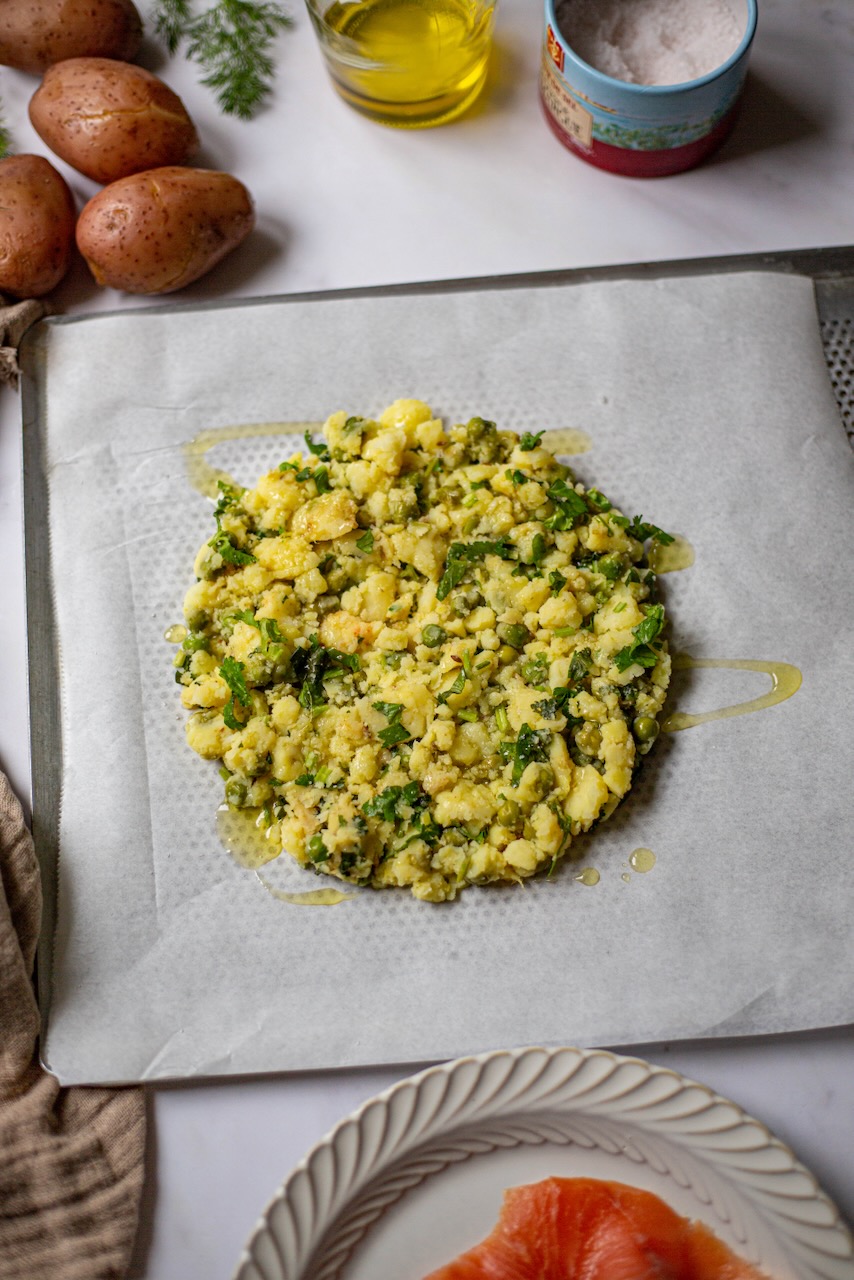 Golden potato tart base with parsley on parchment paper
