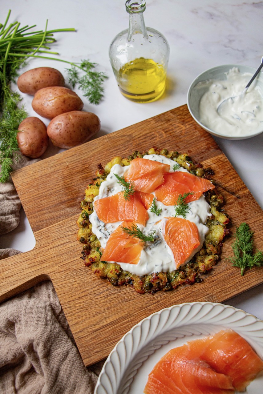 Potato tart base topped with yogurt and smoked salmon, fresh herbs