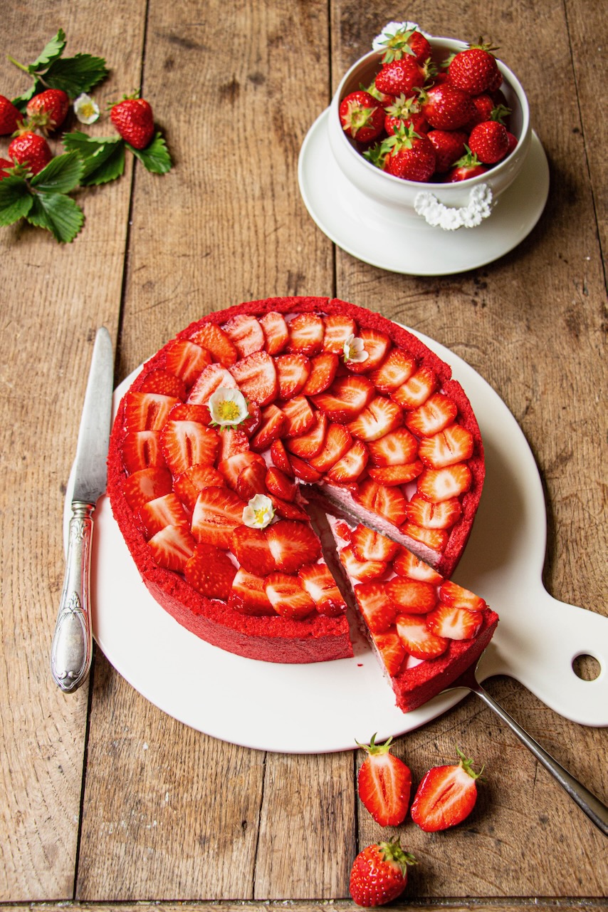 Strawberry Bavarian cream decorated with fresh strawberry slices on a rustic wooden board