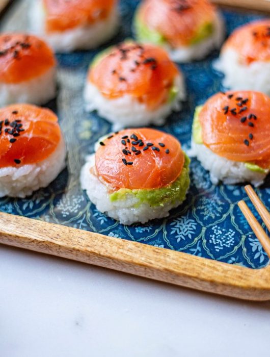 Assortiment de sushi balls au saumon et sésame noir sur plateau décoratif