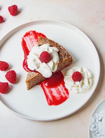 Tranche de gâteau framboise nappée de coulis rouge et crème onctueuse, framboises fraîches