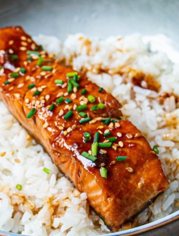 Saumon teriyaki glacé, garni de graines de sésame et ciboulette sur riz blanc moelleux