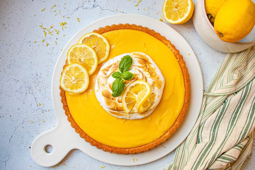 Gâteau au citron meringué avec tranches de citron et feuille de basilic, vue de dessus