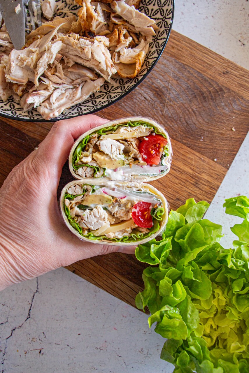 Roasted chicken protein wrap cut in half, filled with lettuce and tomato